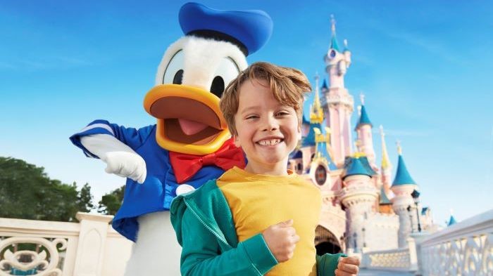 Donald Duck mit Jungen vor dem Disney-Schloss