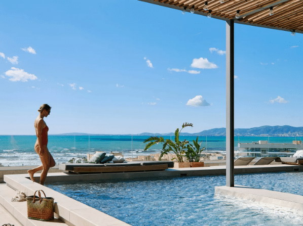 Frau steigt auf Dachterrasse in den Pool