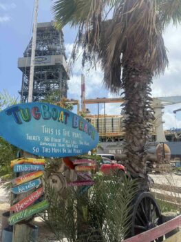 Eingangsschild vom Tugboat Beach mit Schiff im Hintergrund