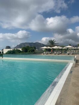 Hotelpool mit wolkigem Himmel, Liegen und Sonnenschirmen