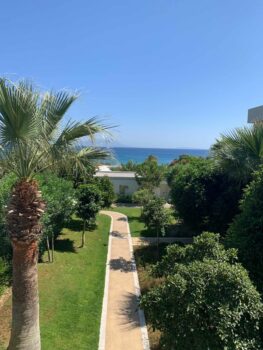 Gang durch den Hotelgarten mit Meer im Hintergrund