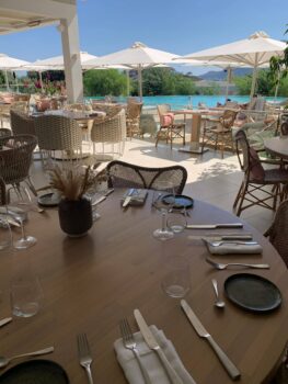 Gedeckter Tisch auf der Terrasse mit Blick auf den Hotelpool