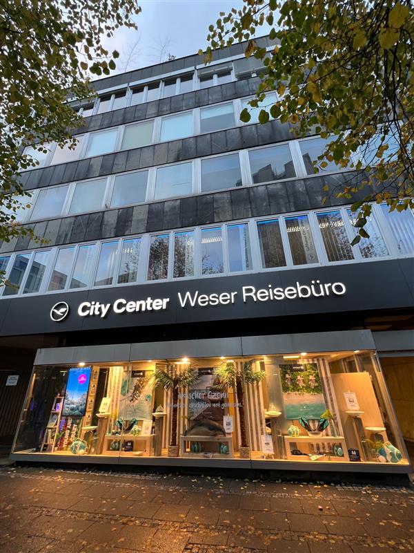 Außenansicht des Weser Reisebüros Bremen in der Dämmerung